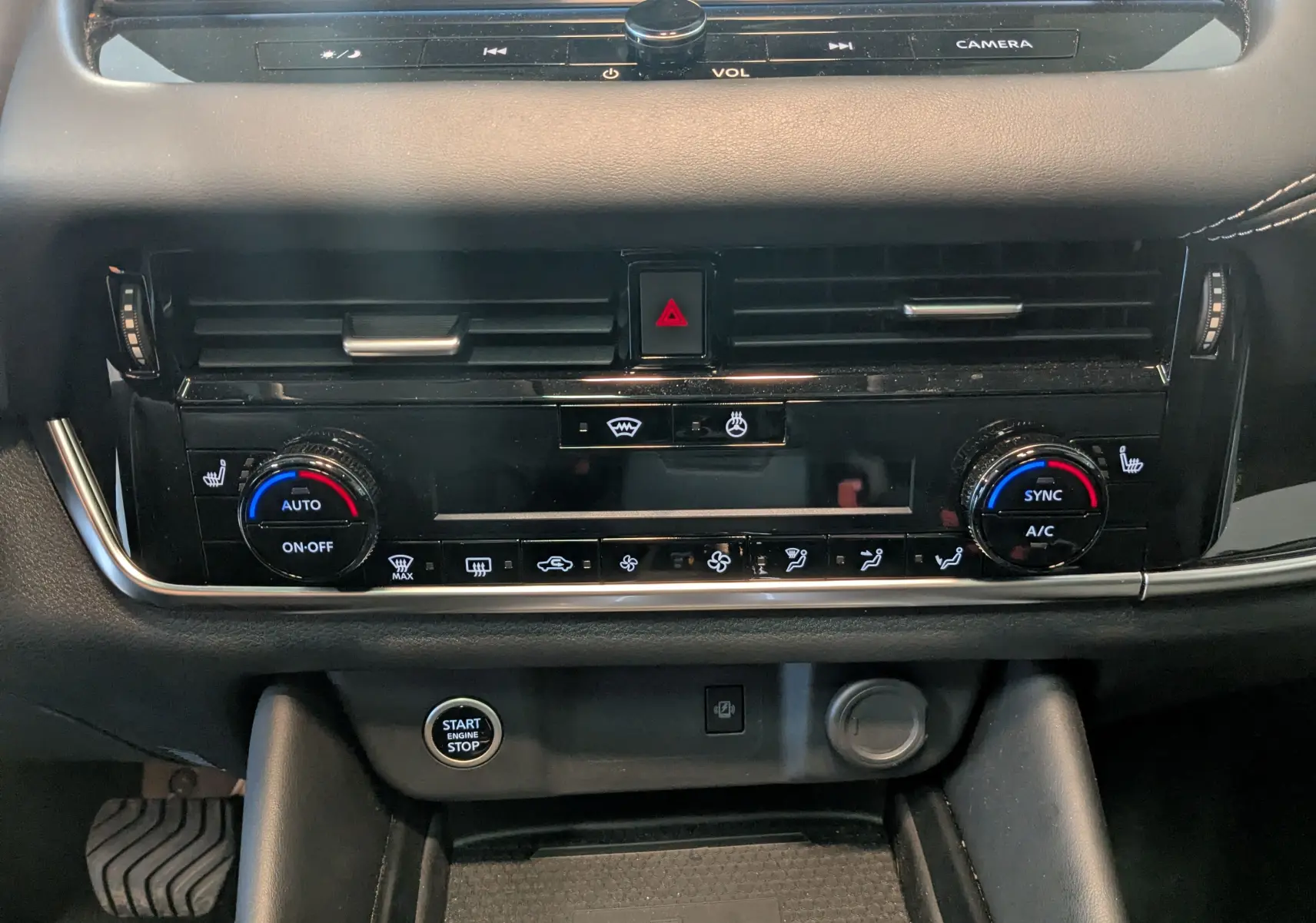 Vue rapprochée du tableau de bord noir du Nissan Qashqai 2024, mettant en valeur la climatisation automatique et le bouton start/stop.