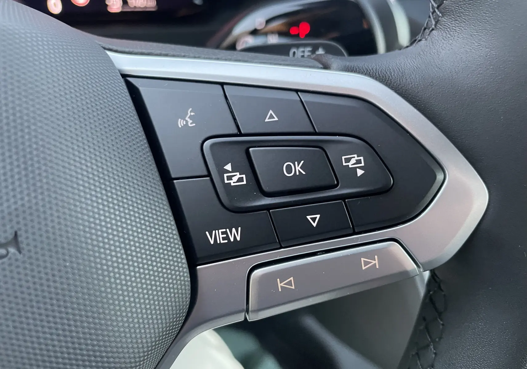 Gros plan sur les commandes multifonctions du volant du Volkswagen Crafter Van 2025 noir intense.