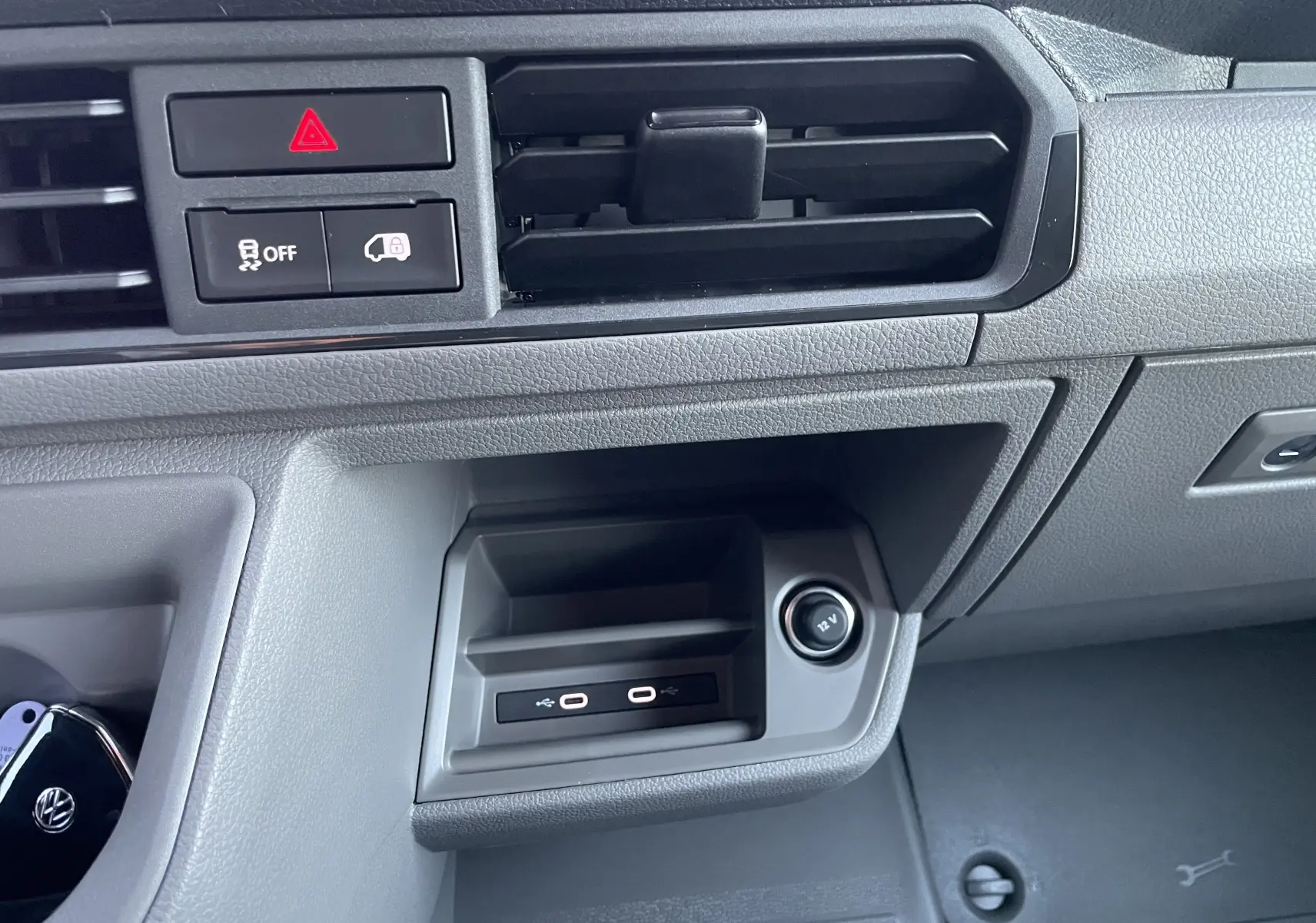 Détail de la console centrale du Volkswagen Crafter 2025 avec ports USB-C et prise 12V, finition gris clair.