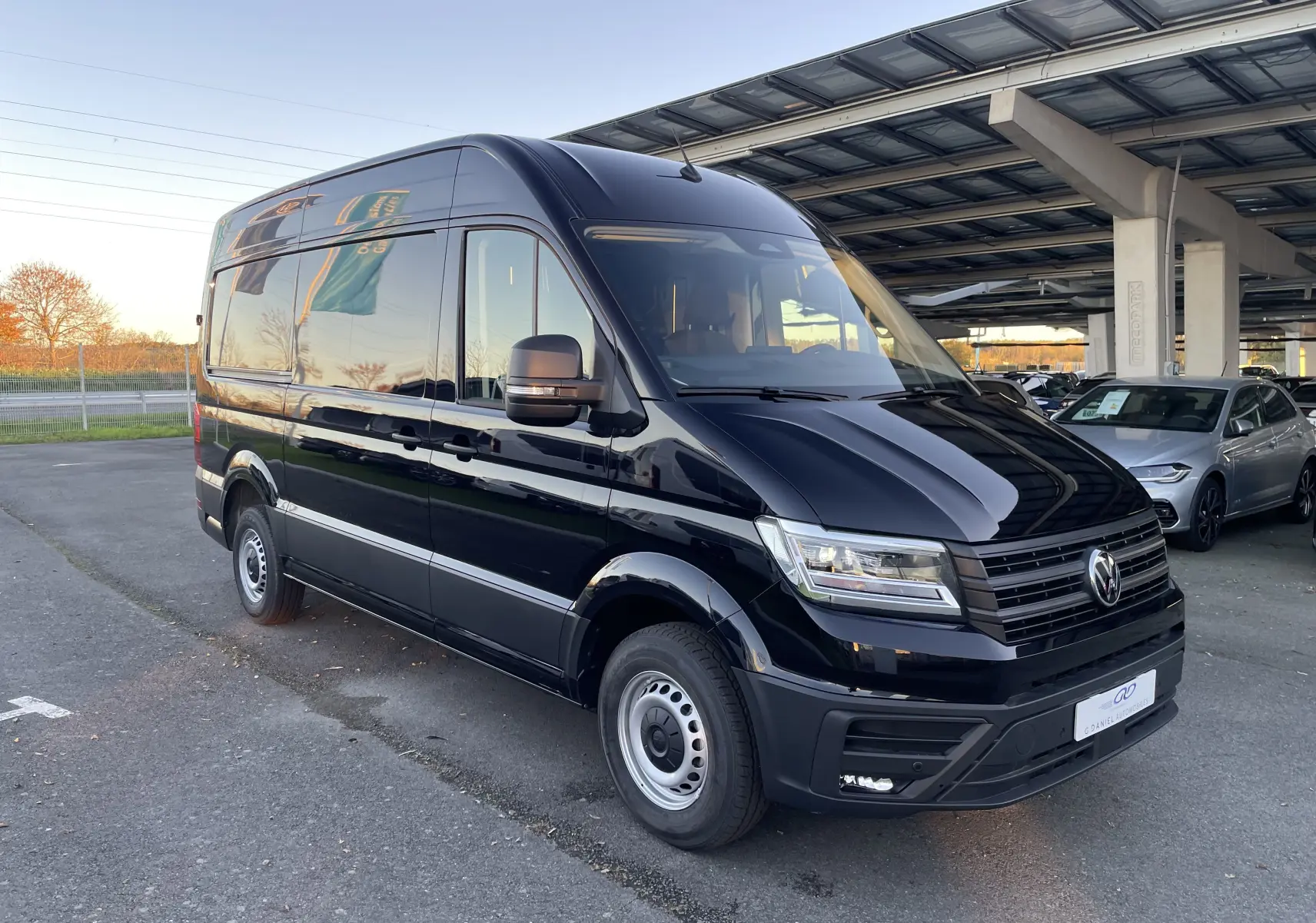 Vue 3/4 avant droit d'un Volkswagen Crafter Van noir intense 2025 avec phares LED et carrosserie haute.