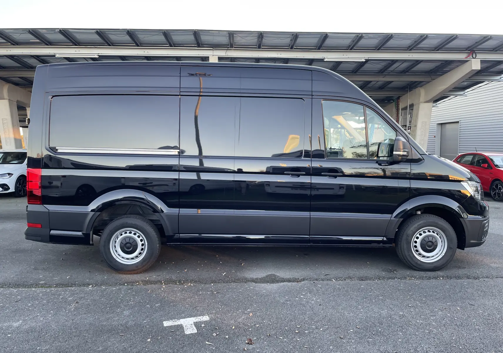 Profil droit du Volkswagen Crafter Van 35 L3H3 noir intense 2025, avec carrosserie haute et roues acier simples.
