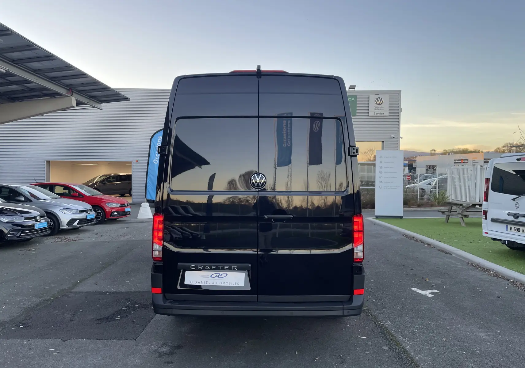 Vue arrière d'un Volkswagen Crafter Van noir intense 2025, avec portes battantes fermées et logo VW visible.