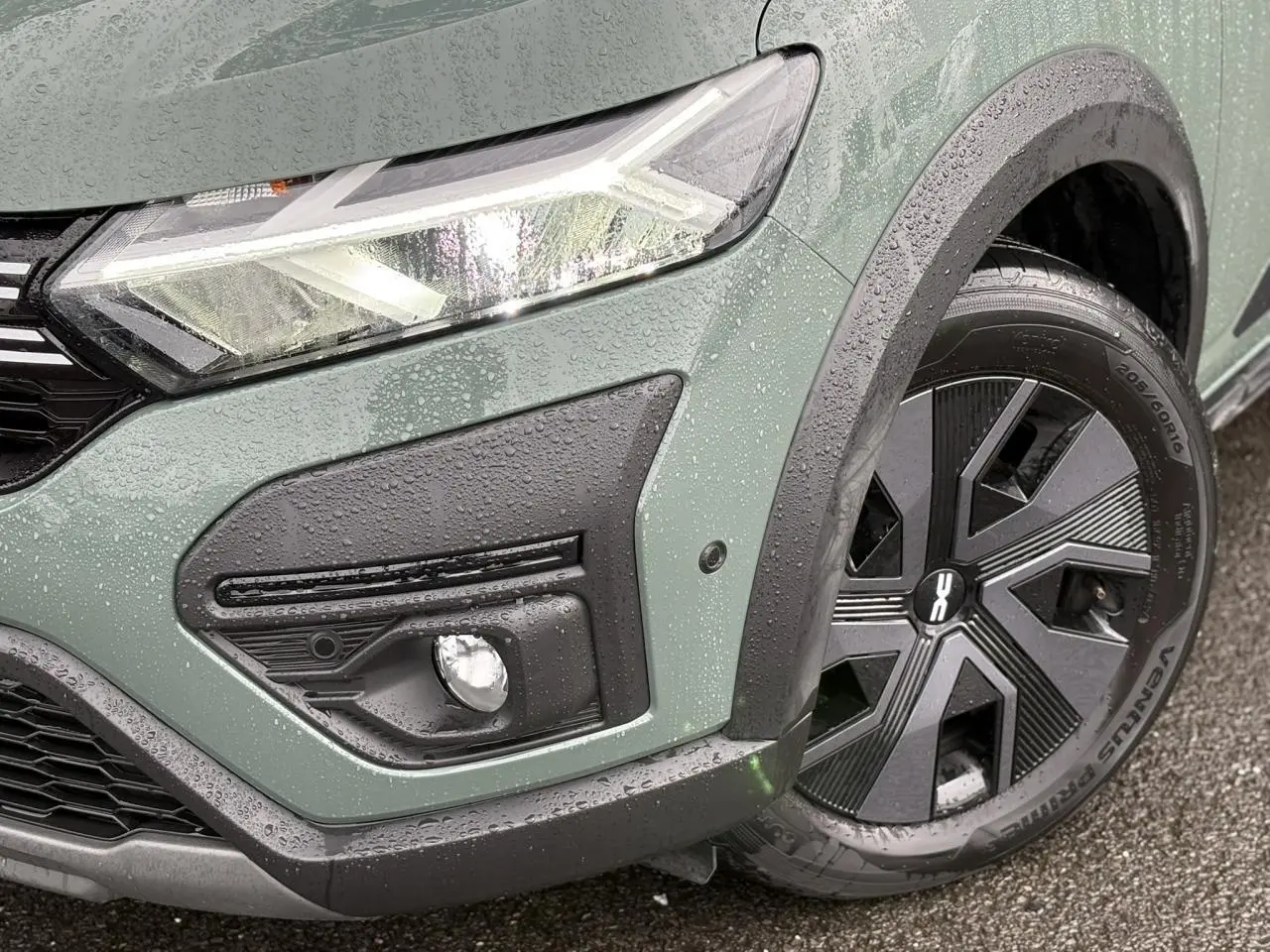 Gros plan sur l'avant droit du Dacia Jogger Kaki Lichen avec phares LED et jante 16 pouces noire mouillée.