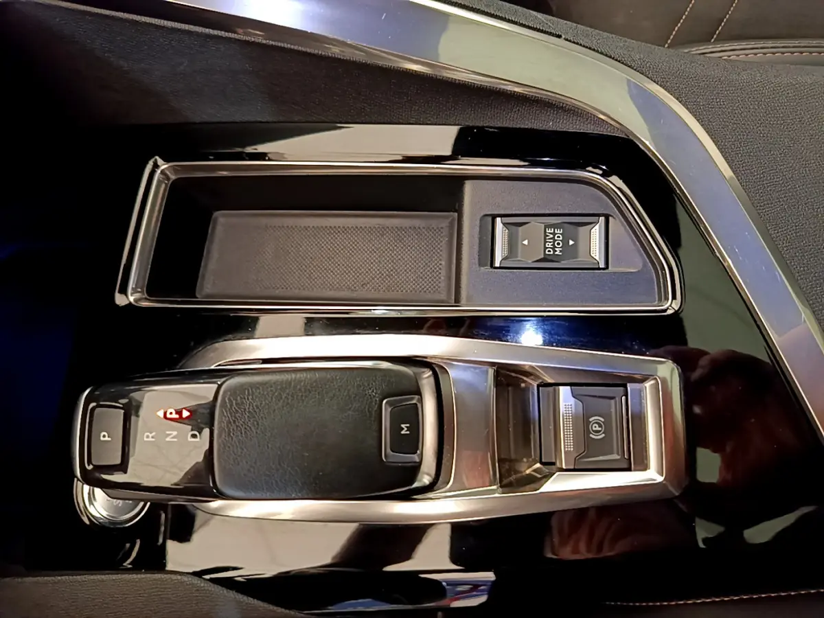 Gros plan sur la console centrale noire brillante du Peugeot 3008 GT 2021 avec levier de vitesses automatique et commandes Drive Mode.