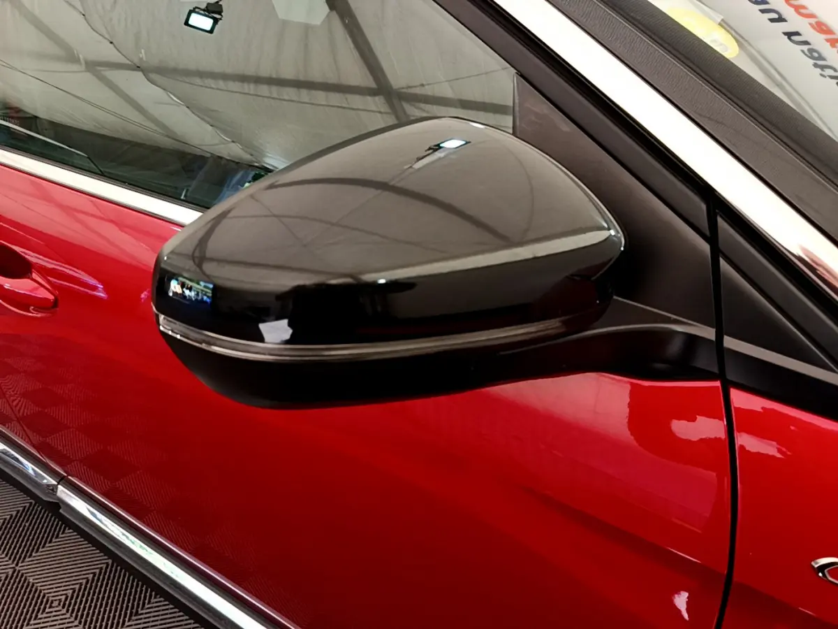 Gros plan sur le rétroviseur noir brillant côté gauche du Peugeot 3008 GT rouge, mettant en valeur la porte et la finition chromée.