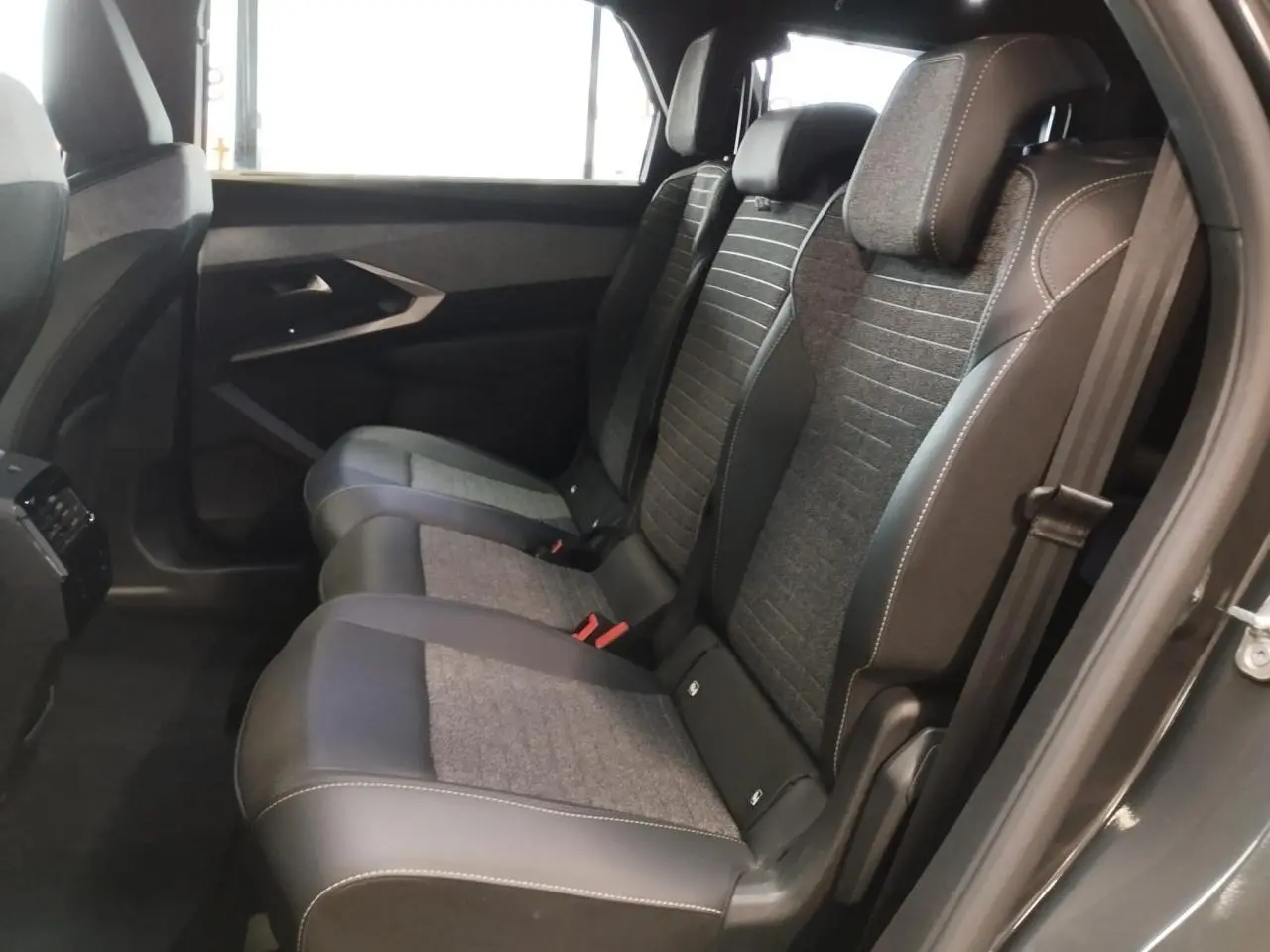 Vue latérale intérieure sur la banquette arrière gris foncé et tissu chiné du Peugeot 5008 2025 finition Allure.