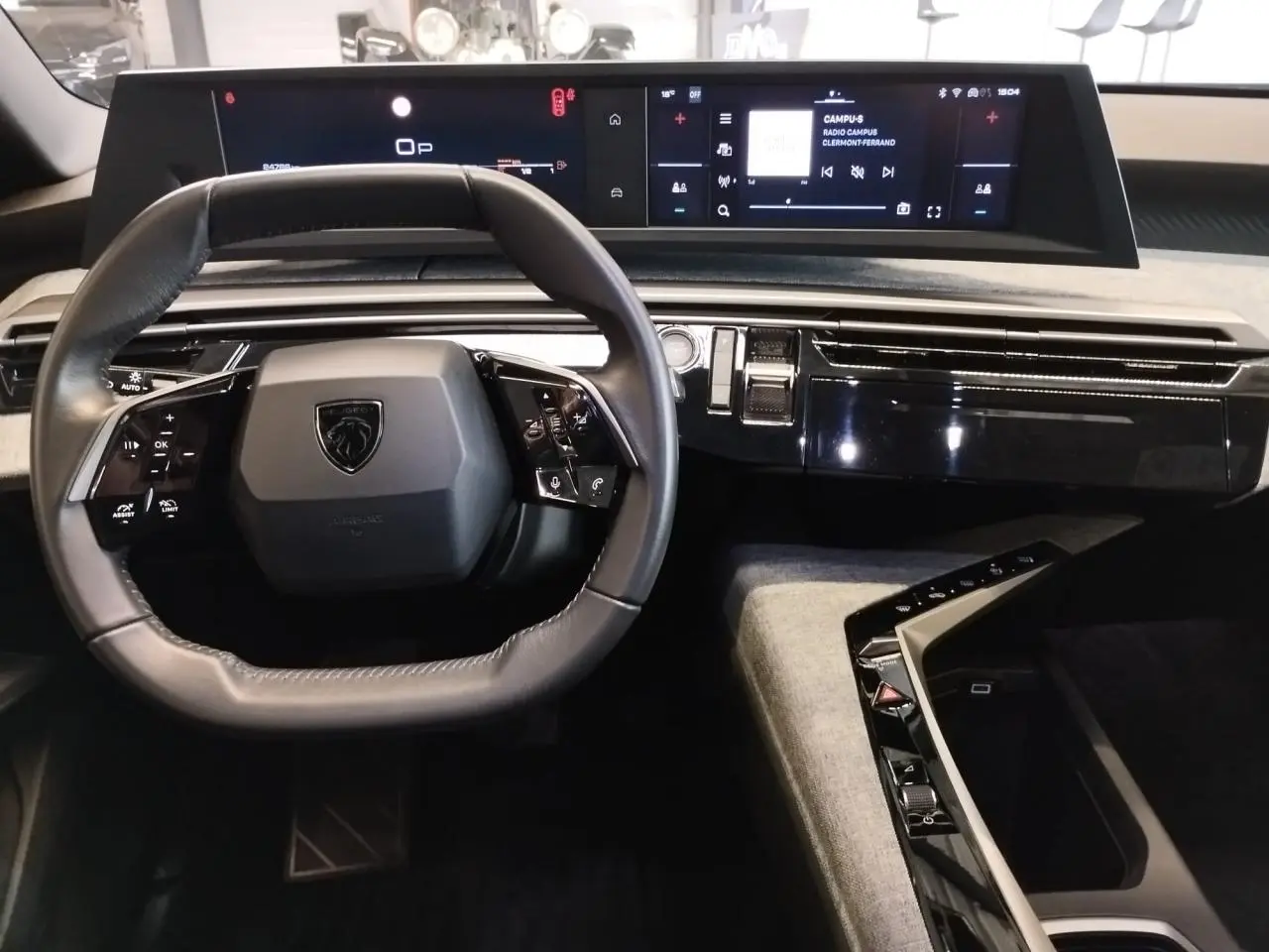 Vue intérieure du poste de conduite du Peugeot 5008 2025, volant compact cuir et double écran HD panoramique.