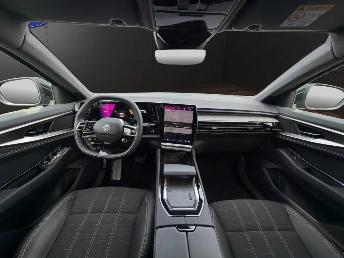 Vue intérieure avant du Renault Austral techno E-Tech 2025, tableau de bord noir avec écran tactile central vertical.
