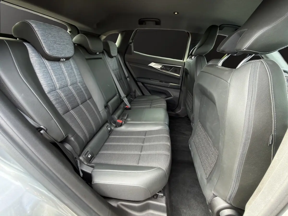 Vue latérale intérieure des sièges arrière en cuir noir du Renault Austral gris foncé, avec banquette 3 places et appuie-têtes.