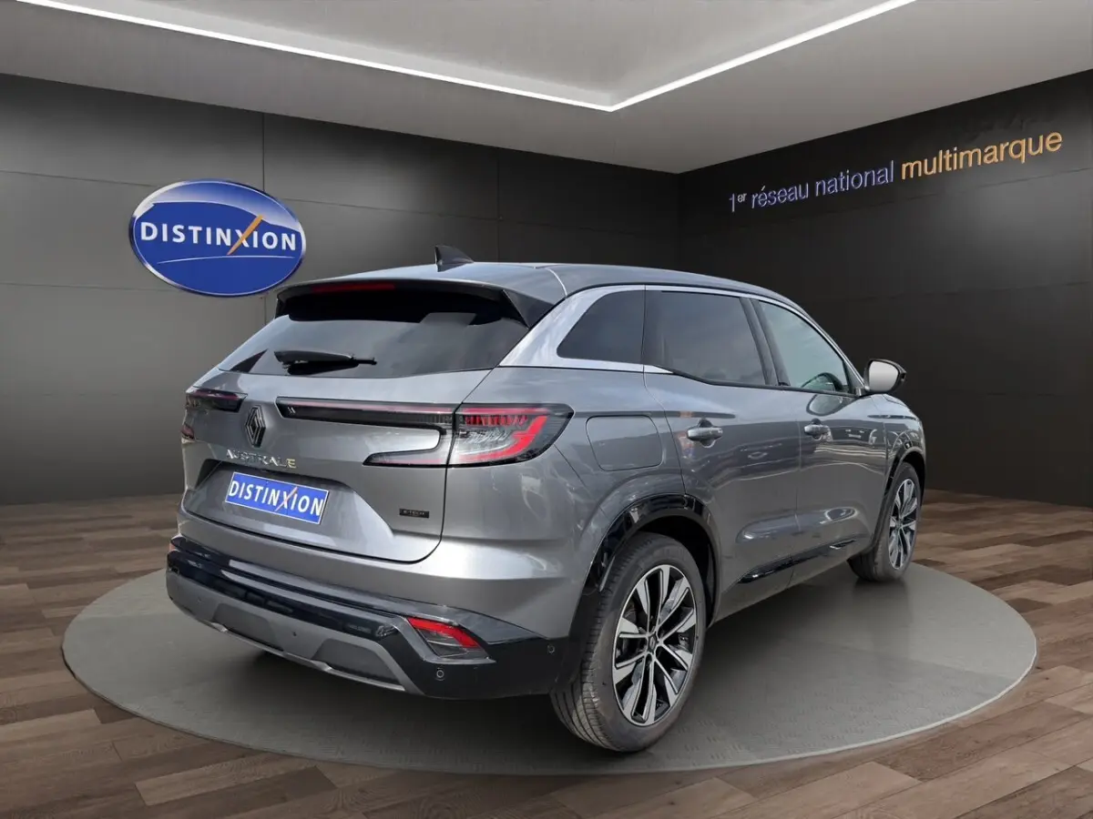 Renault Austral gris foncé en 3/4 arrière droit, avec feux LED et jantes alliage visibles en showroom.