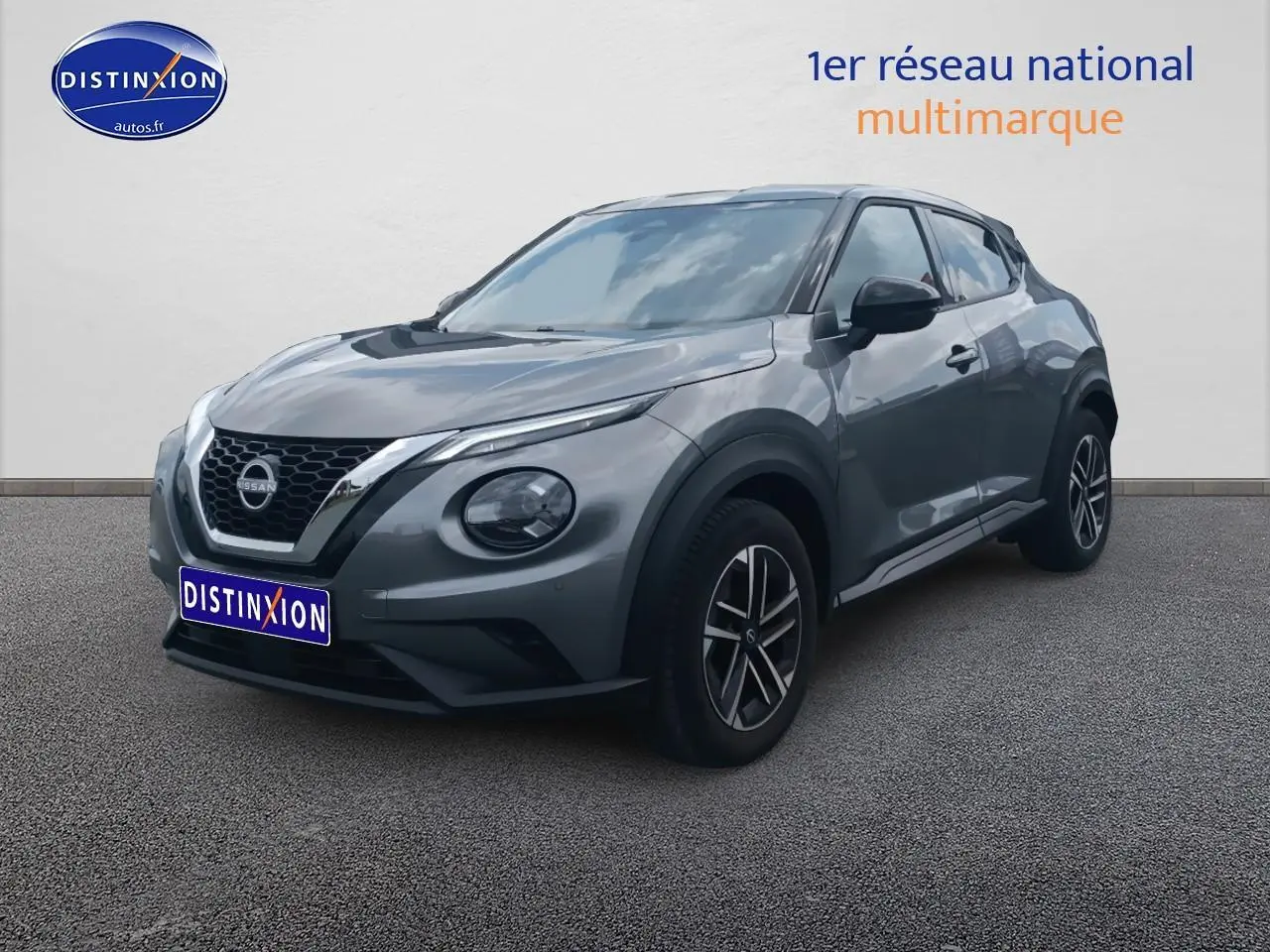 Nissan Juke gris 2025 vue 3/4 avant droit, avec jantes alu et phares avant LED distinctifs.