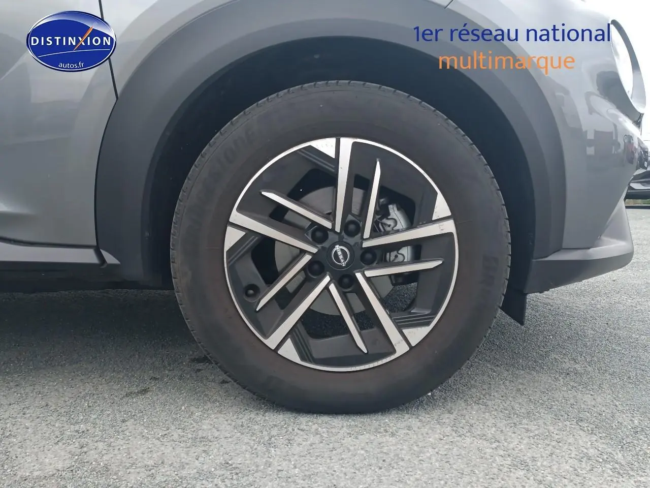 Gros plan sur la roue avant droite du Nissan Juke gris 2025 avec jante alliage et partie du pare-chocs avant visible.