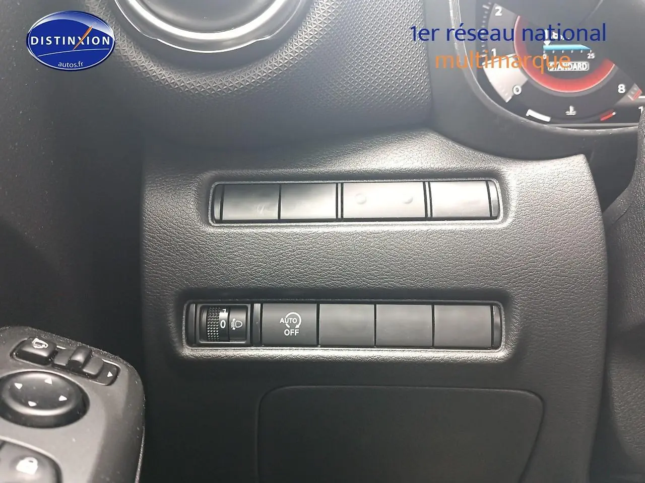 Détail du tableau de bord noir du Nissan Juke 2025 avec commandes d'éclairage et réglages côté gauche.