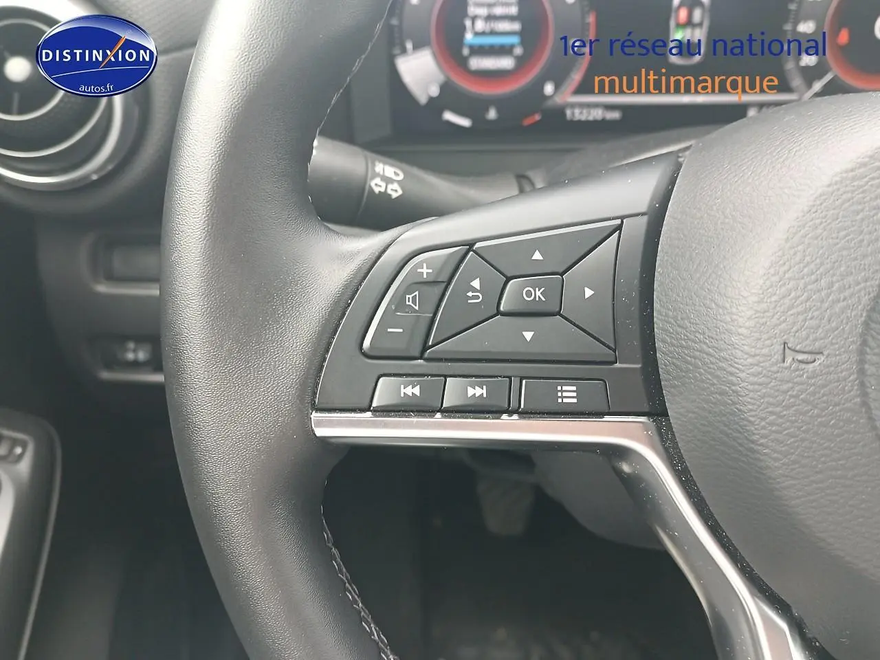 Gros plan sur le volant cuir multifonction côté gauche du Nissan Juke gris 2025 avec commandes audio intégrées.