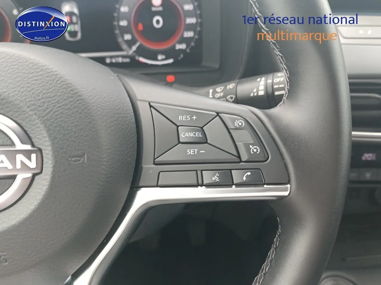 Gros plan sur le volant cuir multifonction du Nissan Juke gris 2025, avec commandes de régulateur et téléphone intégrées.