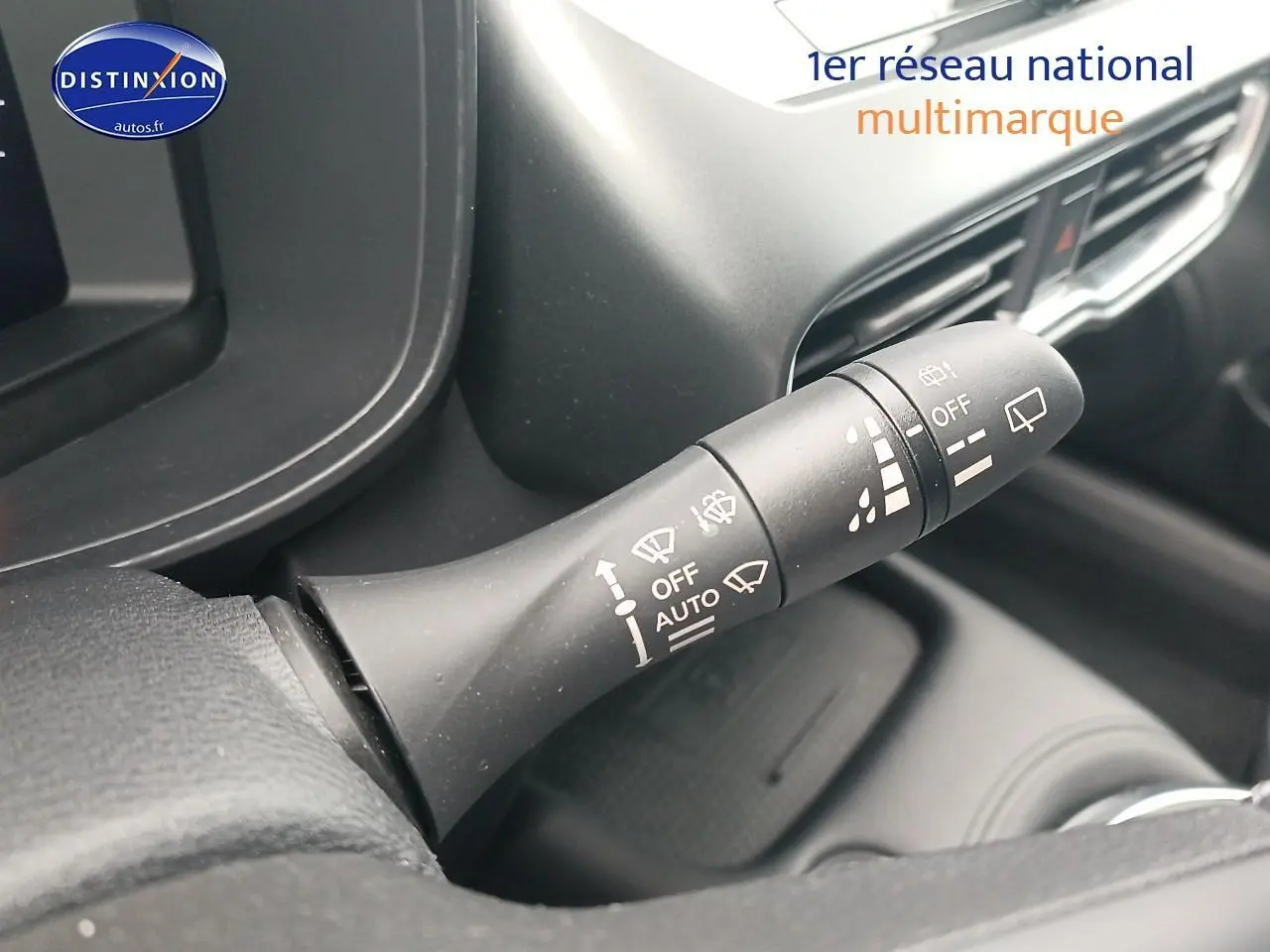 Gros plan sur la commande des essuie-glaces dans l'habitacle du Nissan Juke gris 2025, côté gauche du volant.