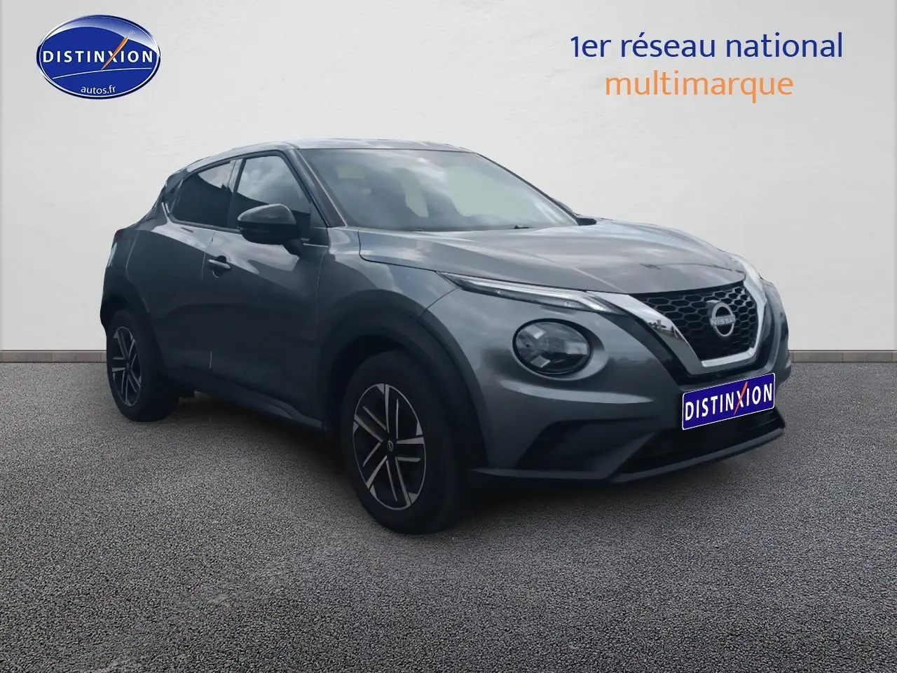 Nissan Juke gris 2025 en 3/4 avant droit, avec phares ronds et jantes alliage noires.