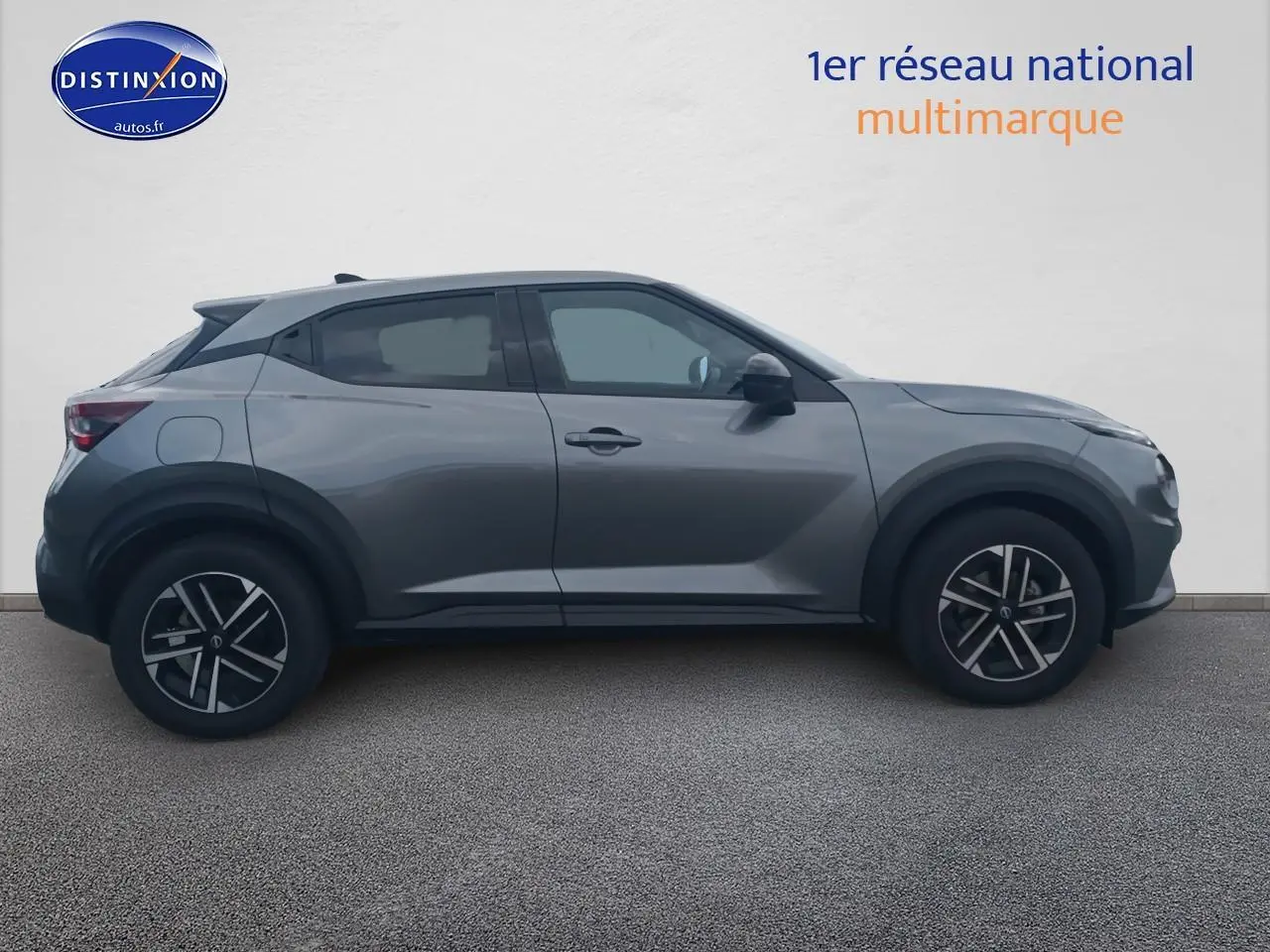 Profil côté gauche du Nissan Juke gris 2025 avec jantes alu et poignées ton carrosserie sur fond neutre.