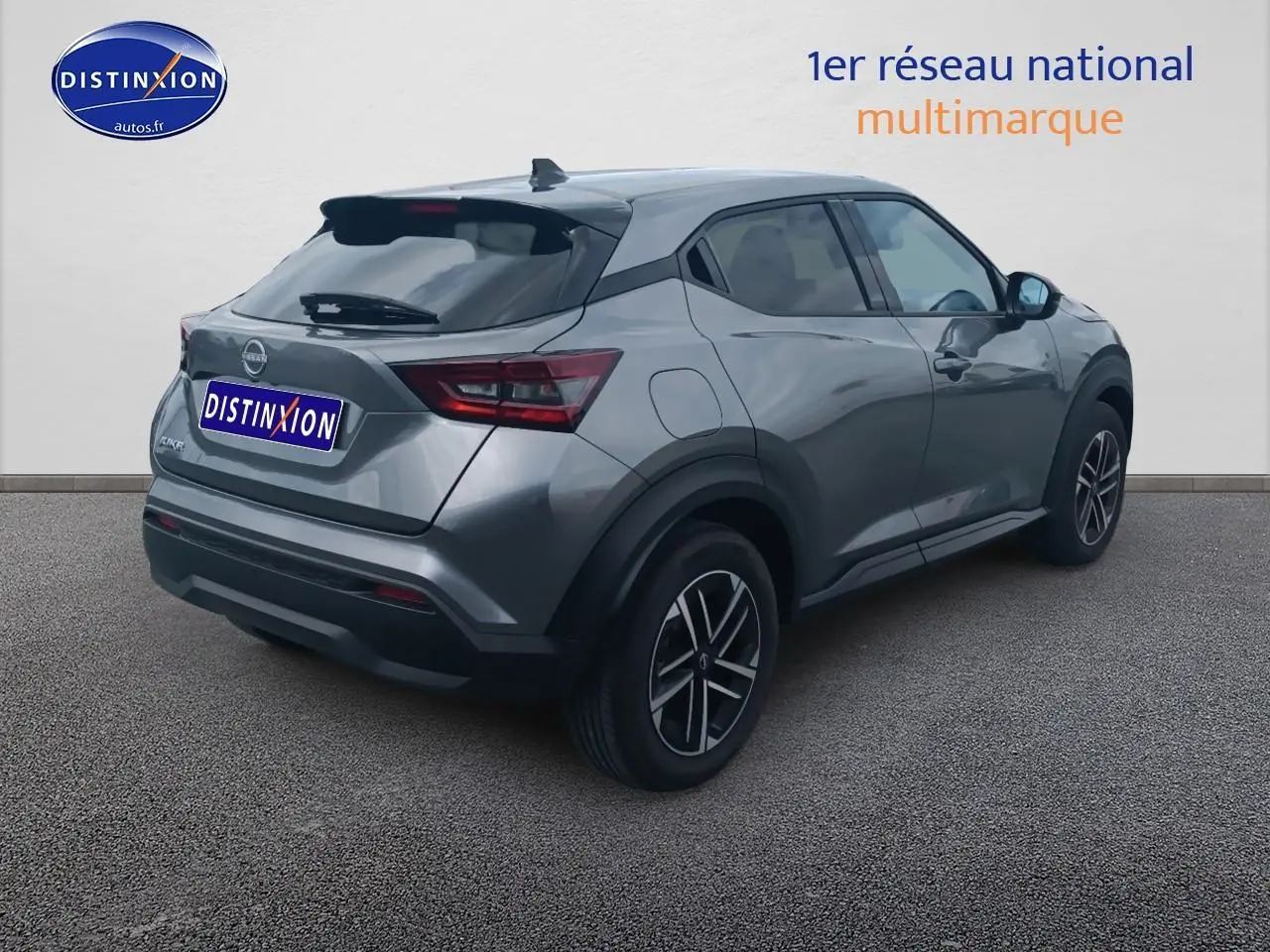 Nissan Juke gris en 3/4 arrière droit, avec jantes alliage et vitres arrière surteintées.