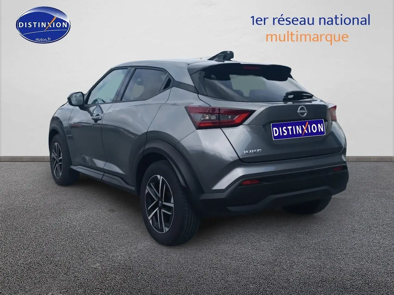 Nissan Juke gris en 3/4 arrière droit, avec jantes alu et feux arrière LED distinctifs.