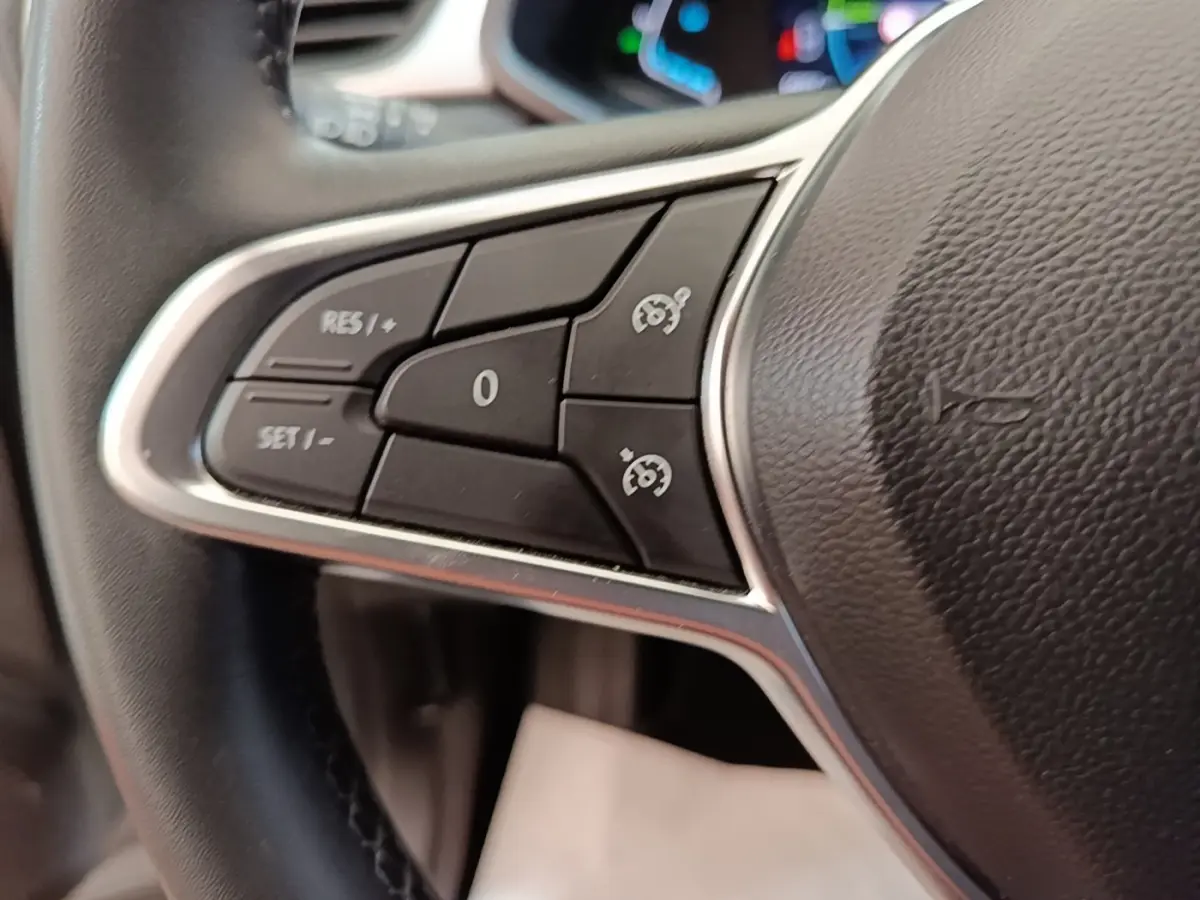 Gros plan sur le côté gauche du volant cuir synthétique du Renault Captur Business E-Tech hybride gris clair 2022, avec commandes multifonctions.