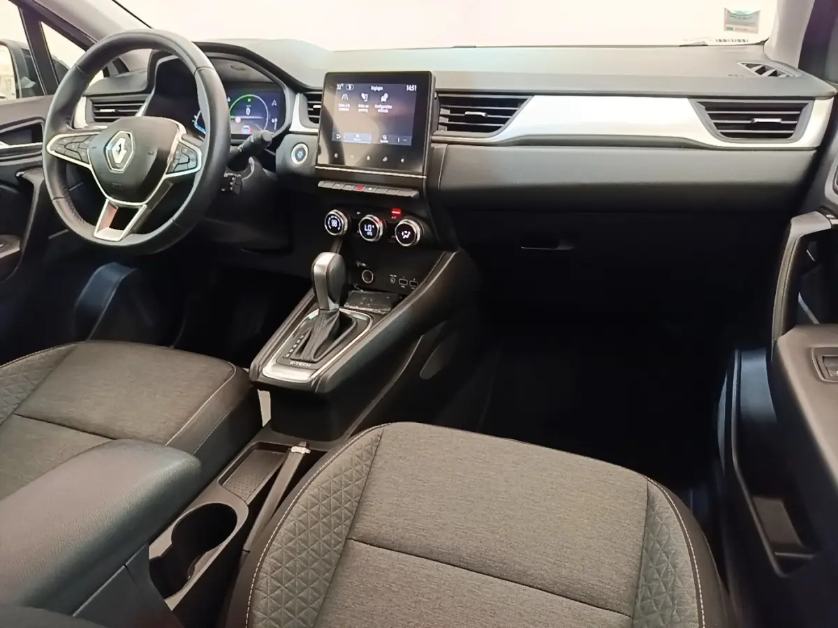 Intérieur avant du Renault Captur Business E-Tech gris clair, volant multifonctions et écran tactile central visible.