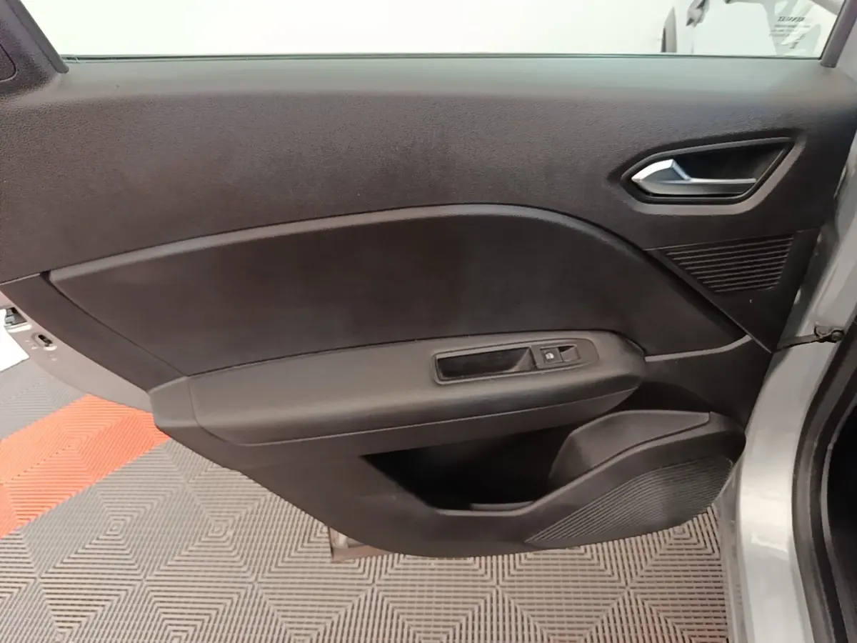 Vue rapprochée de la porte avant droite grise du Renault Captur Business E-Tech hybride avec commandes de fenêtre et poignée intégrée.