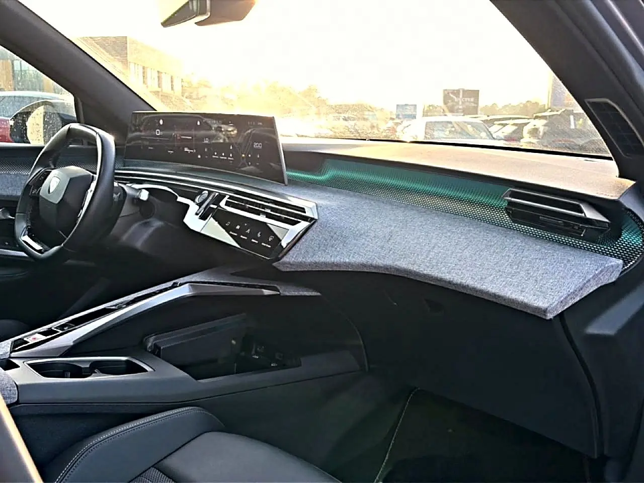 Vue intérieure côté passager du tableau de bord gris et noir du Peugeot 3008 1.2 hybrid 145 GT e-DCS6 avec écran tactile panoramique.