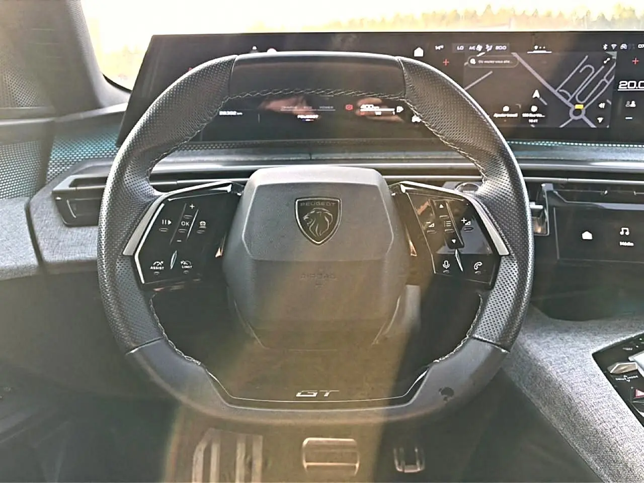 Vue frontale du volant cuir noir multifonction de la Peugeot 3008 gris 1.2 hybrid 145 GT avec tableau de bord numérique.