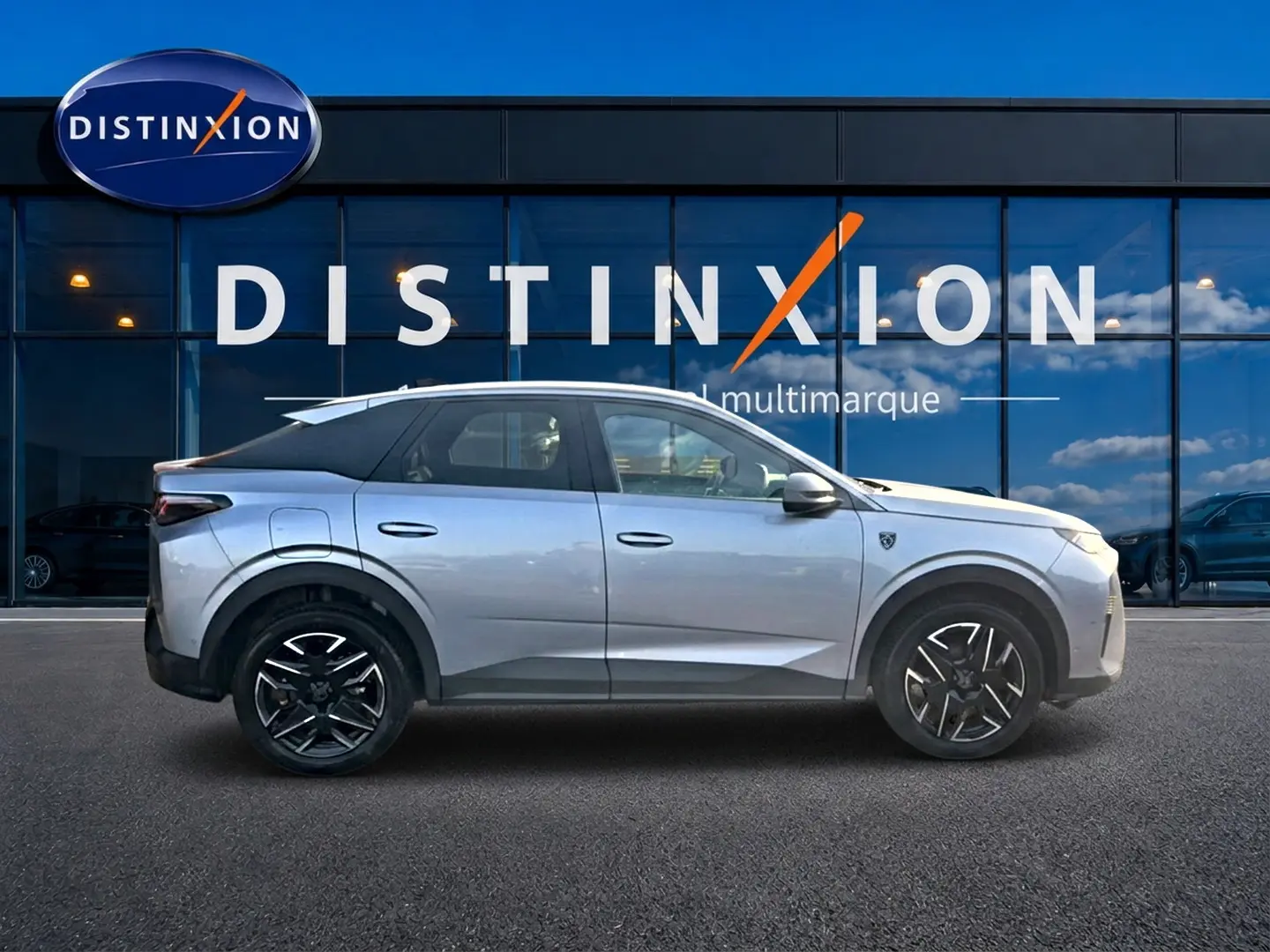 Profil droit du Peugeot 3008 gris 2025 avec jantes alu noires, devant une vitrine Distinxion multimarque.