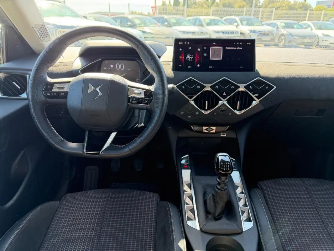 Intérieur du DS3 2024 en vue frontale, volant compact, tableau de bord moderne avec écran tactile et levier de vitesse manuel.