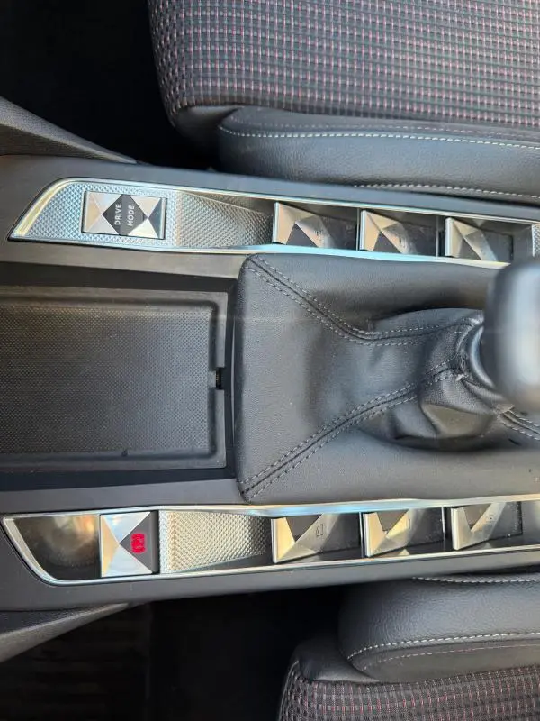 Gros plan sur la console centrale grise du DS3 2024, avec levier de vitesse manuel et boutons en relief chromés.