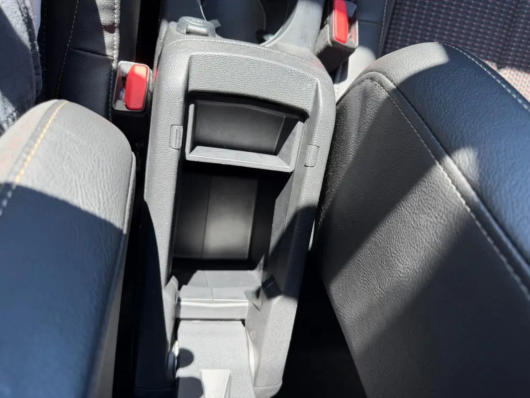 Vue rapprochée de la console centrale ouverte du DS3 100 BVM6 Performance Line 2024, intérieur gris avec surpiqûres.