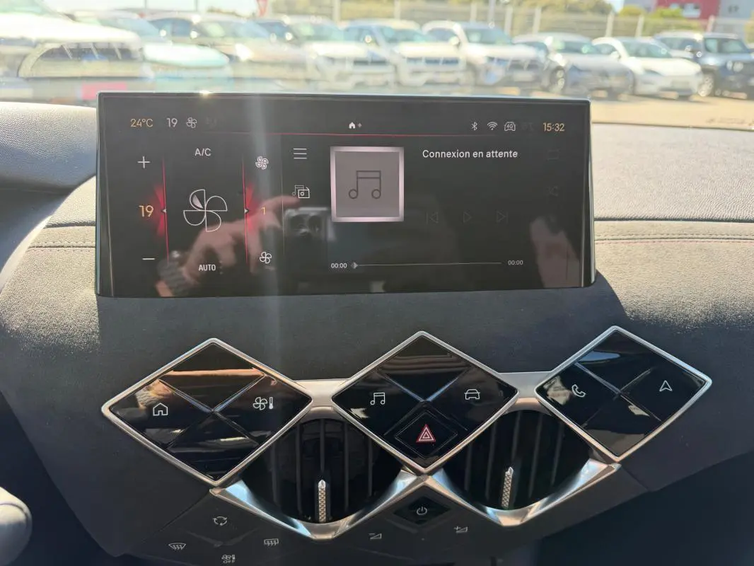 Vue rapprochée de la console centrale du DS3 2024 gris, avec écran tactile et commandes en losange distinctives.