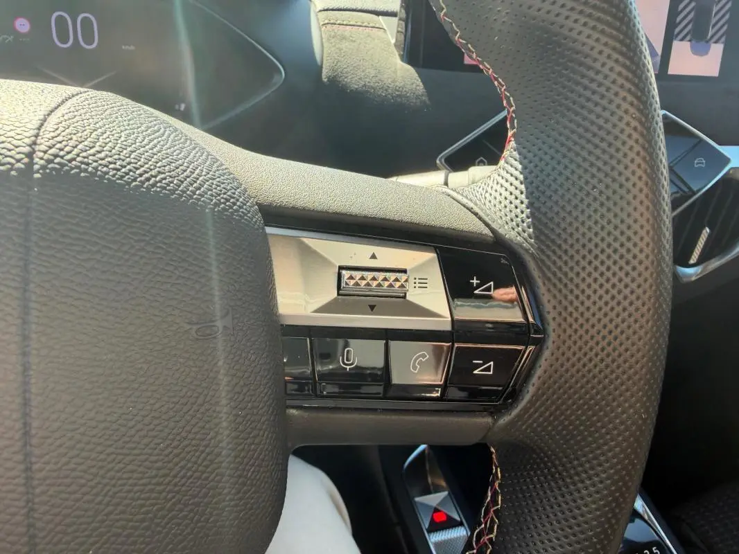 Détail du volant perforé avec commandes multifonctions du DS3 100 BVM6 Performance Line 2024 gris, vue rapprochée intérieure.