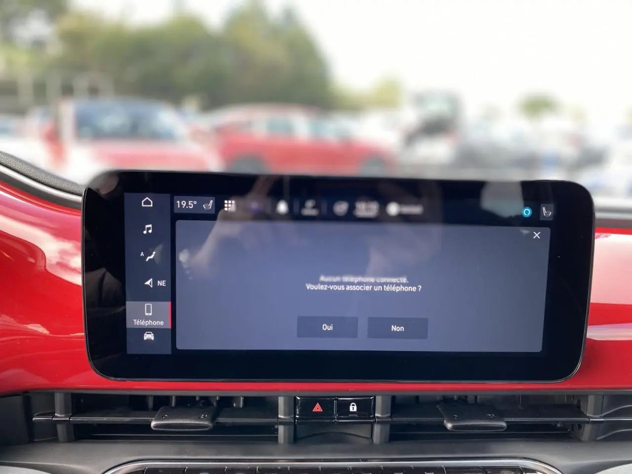 Écran tactile central du tableau de bord rouge d'une Fiat 500 Cabriolet Electrique 2022 affichant une demande d'association téléphonique.