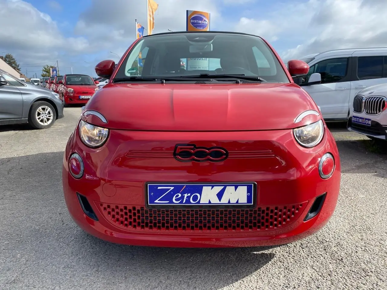 Vue de face d'une FIAT 500 Cabriolet Electrique rouge avec logo 500 noir et plaque Zéro KM visible.