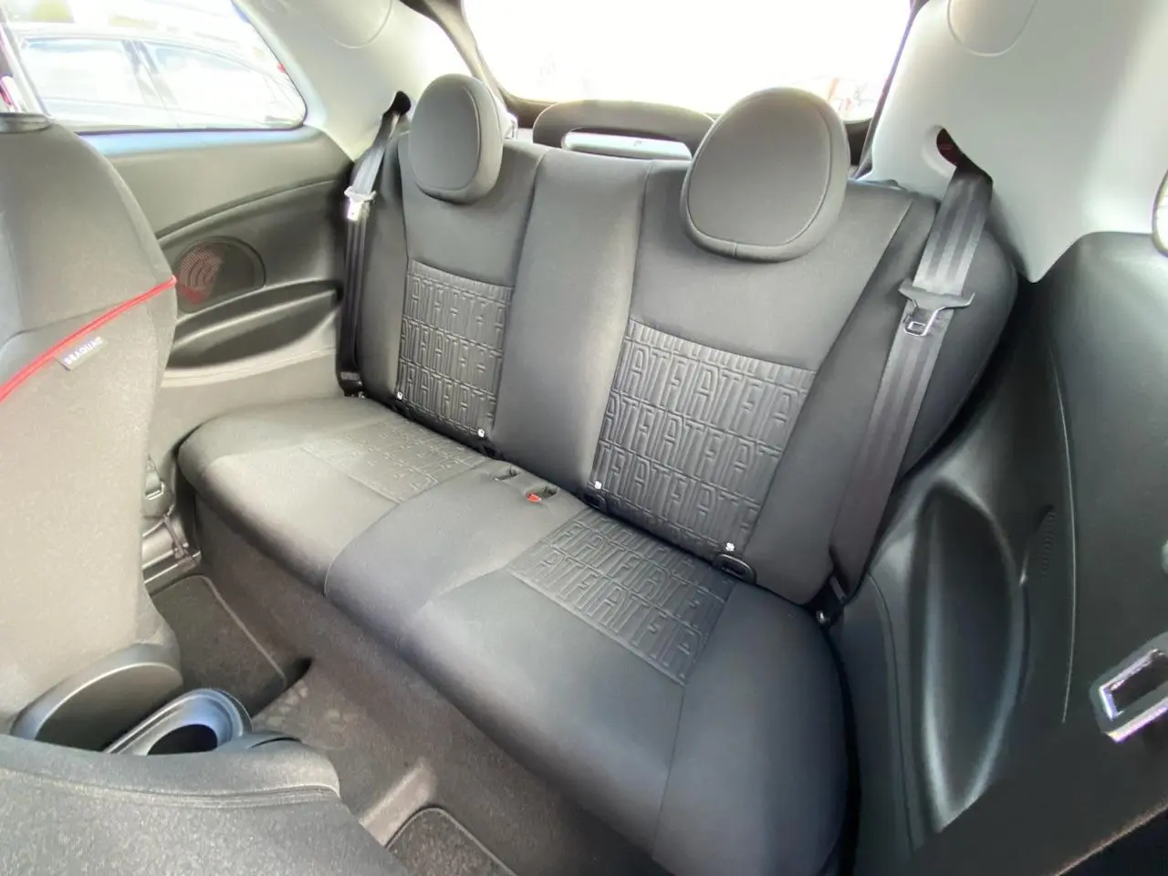 Banquette arrière noire avec motifs FIAT embossés, vue intérieure côté droit du Fiat 500 Cabriolet Electrique rouge.