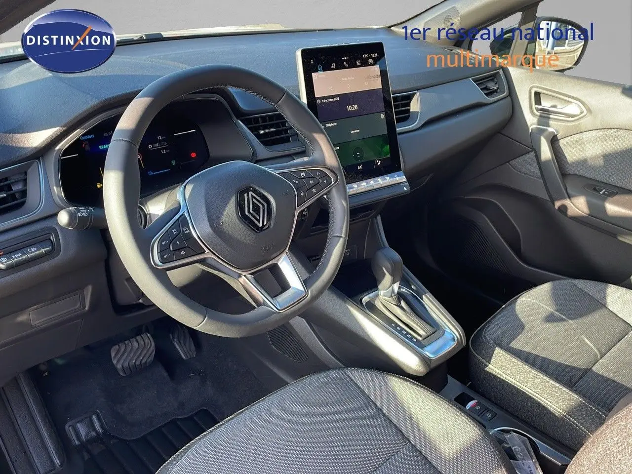 Vue intérieure avant du Renault Captur E-Tech gris rafale avec tableau de bord numérique et écran tactile central vertical.
