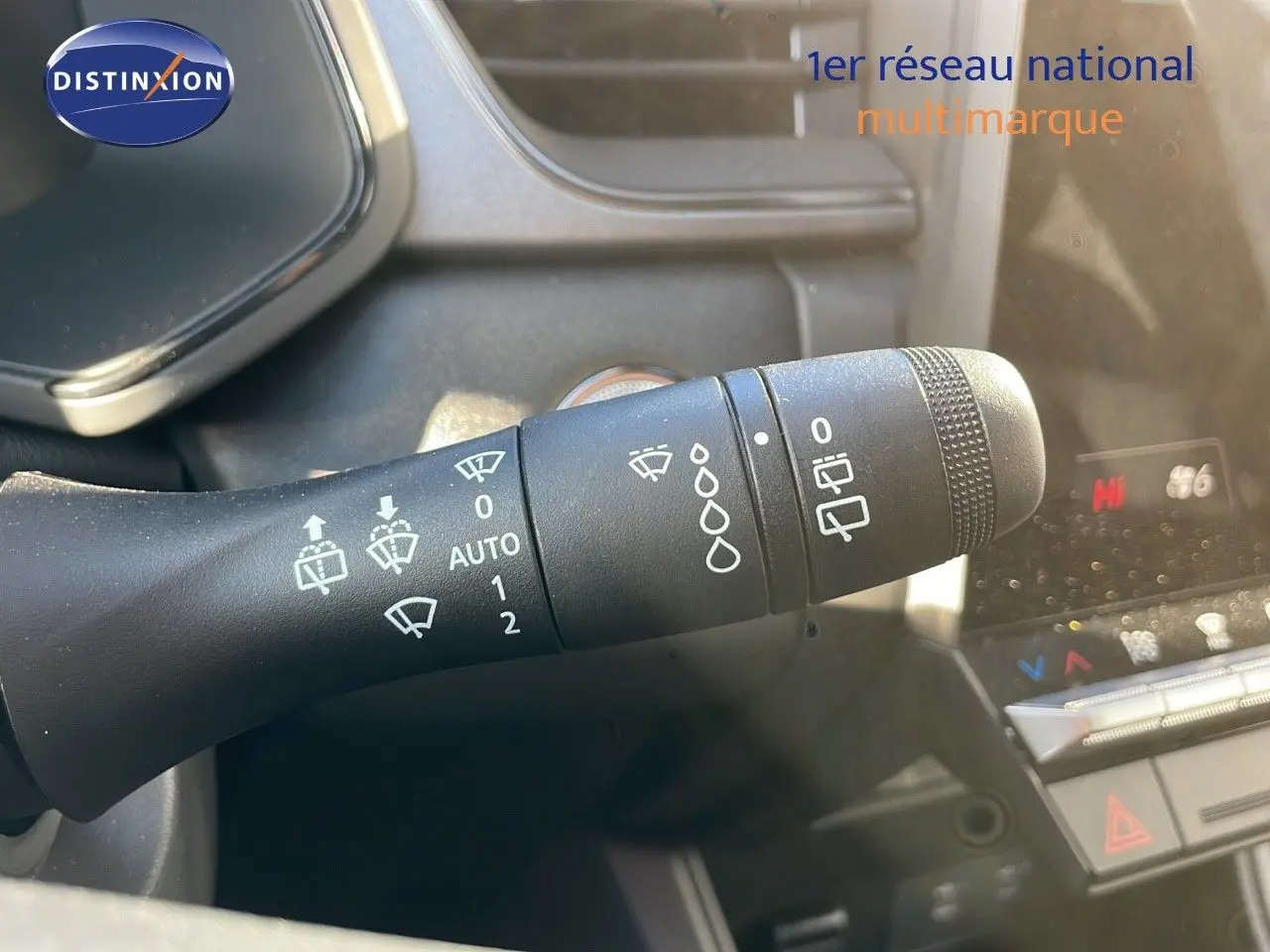 Gros plan sur la commande d'essuie-glaces du Renault Captur gris Rafale, avec tableau de bord et climatisation en arrière-plan.
