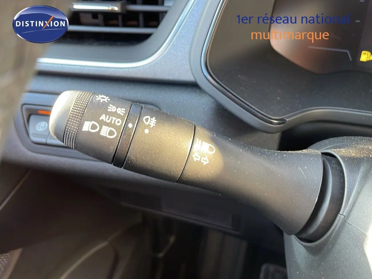 Le commodo des phares et clignotants du Renault Captur E-Tech gris Rafale, vue rapprochée côté gauche du volant.