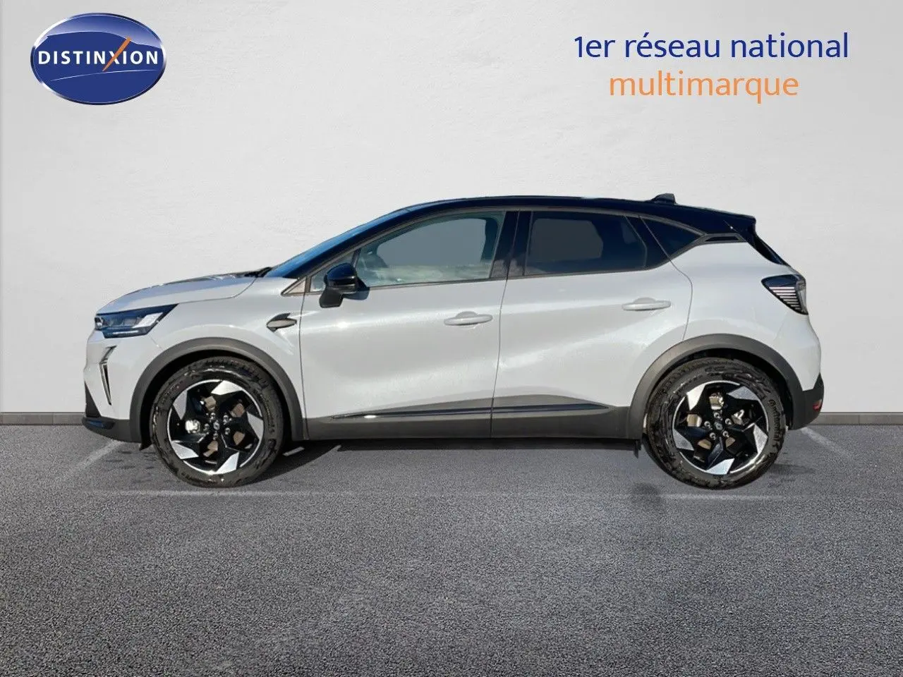 Profil côté gauche du Renault Captur E-Tech hybride 2025 gris Rafale avec toit noir et jantes noires distinctives.