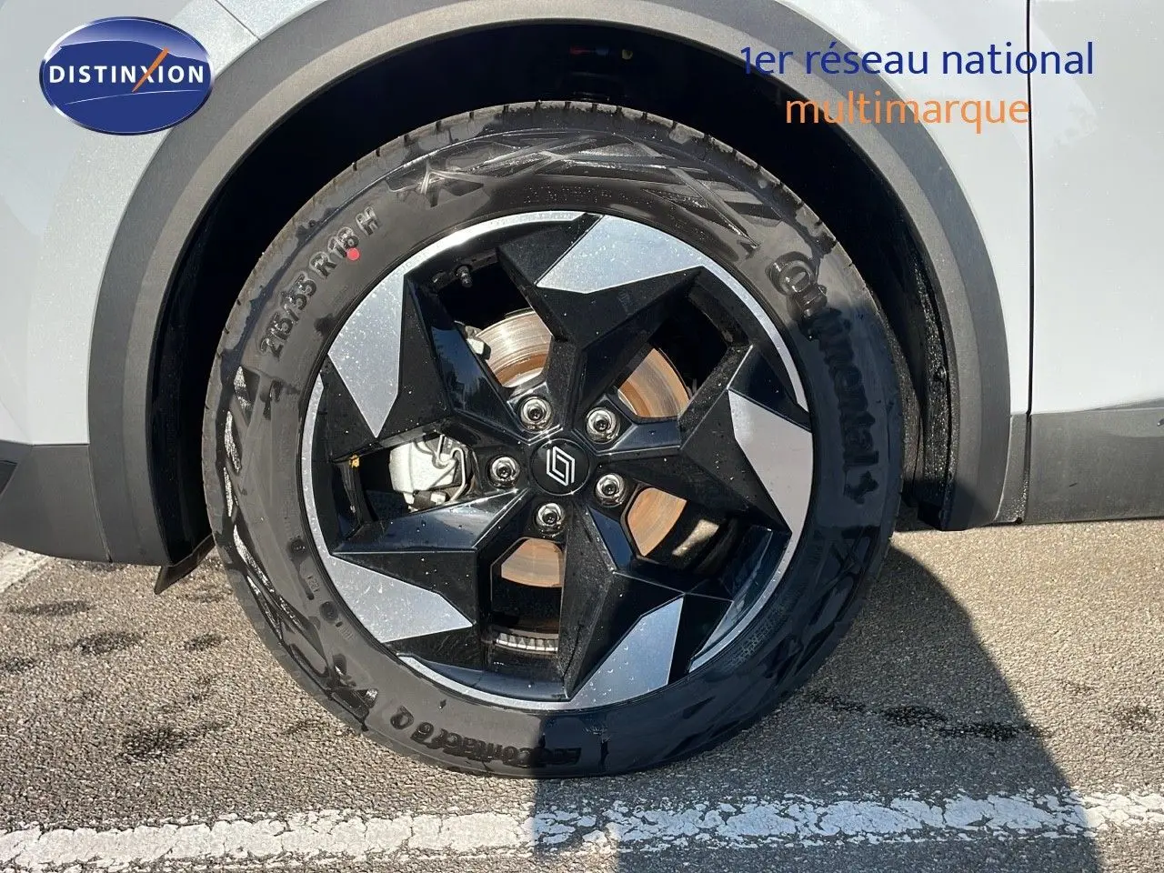 Gros plan sur la roue avant droite du Renault Captur gris Rafale avec jante noire et argentée au design géométrique.