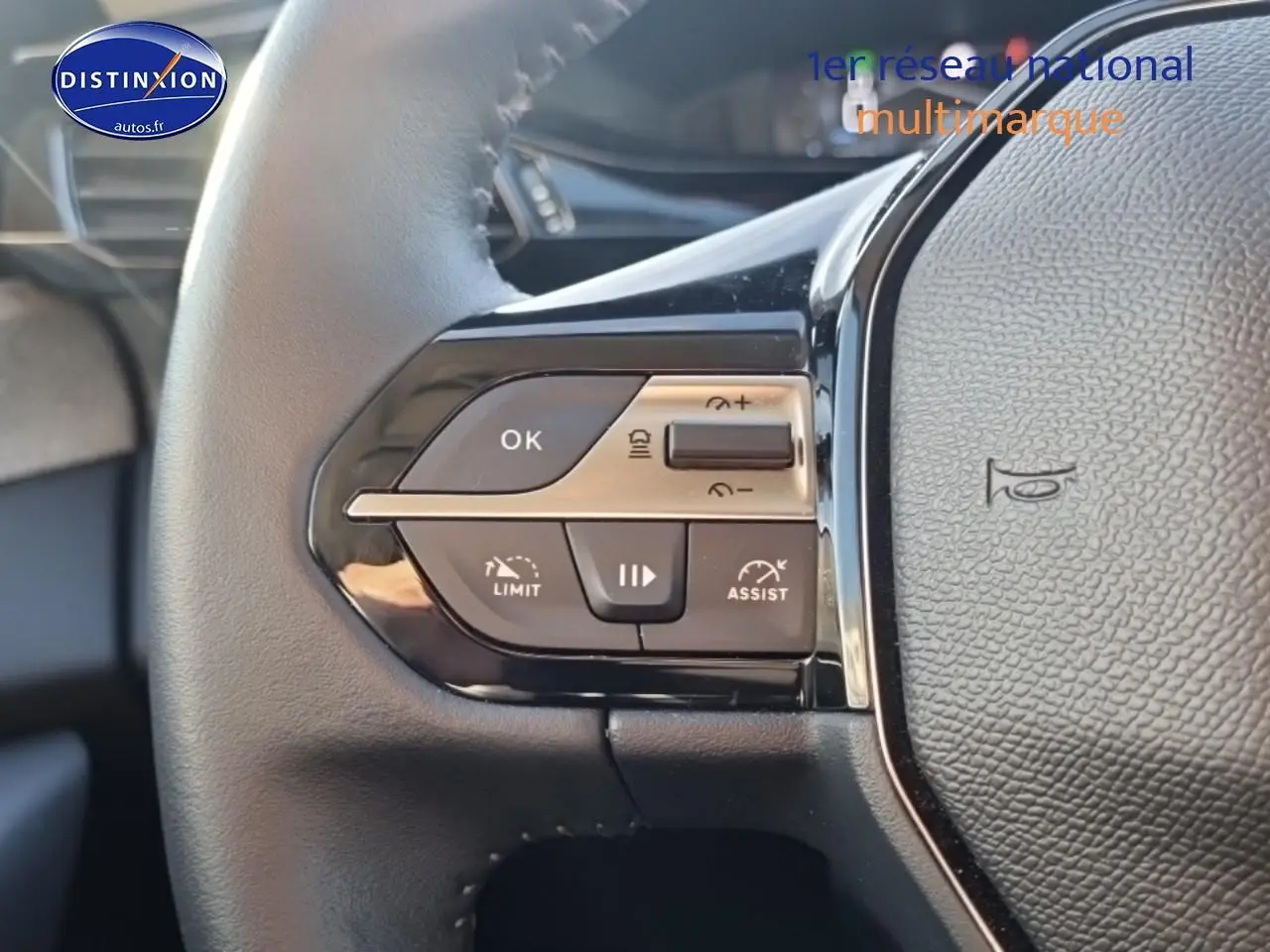 Gros plan sur les commandes gauche du volant cuir noir du Peugeot 408 Hybrid 145 allure 2025.
