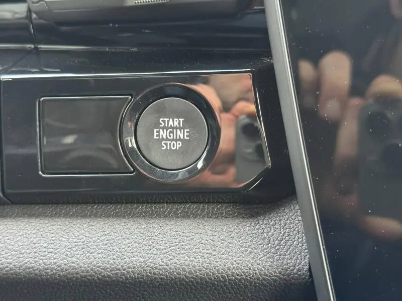 Gros plan sur le bouton Start Engine Stop du tableau de bord du Renault Austral 2025, finition Techno, intérieur noir.