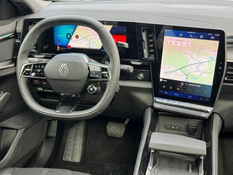 Vue intérieure centrée sur le volant et les écrans numériques du tableau de bord du Renault Austral 2025 hybride.