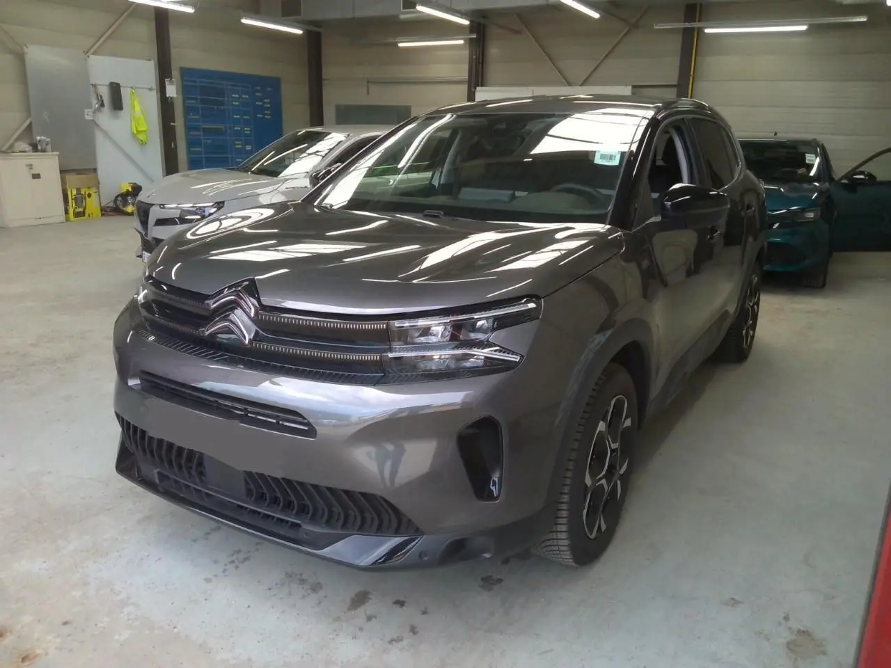 Citroën C5 Aircross gris platinium en 3/4 avant droit, SUV hybride essence avec signature lumineuse distinctive.
