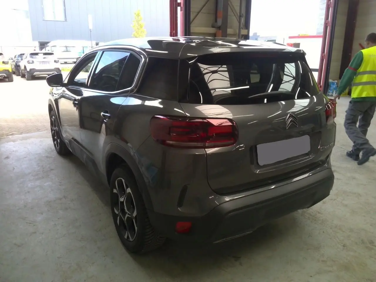 Vue 3/4 arrière du Citroën C5 Aircross gris platinium 2025, soulignant ses feux arrière et jantes distinctives.