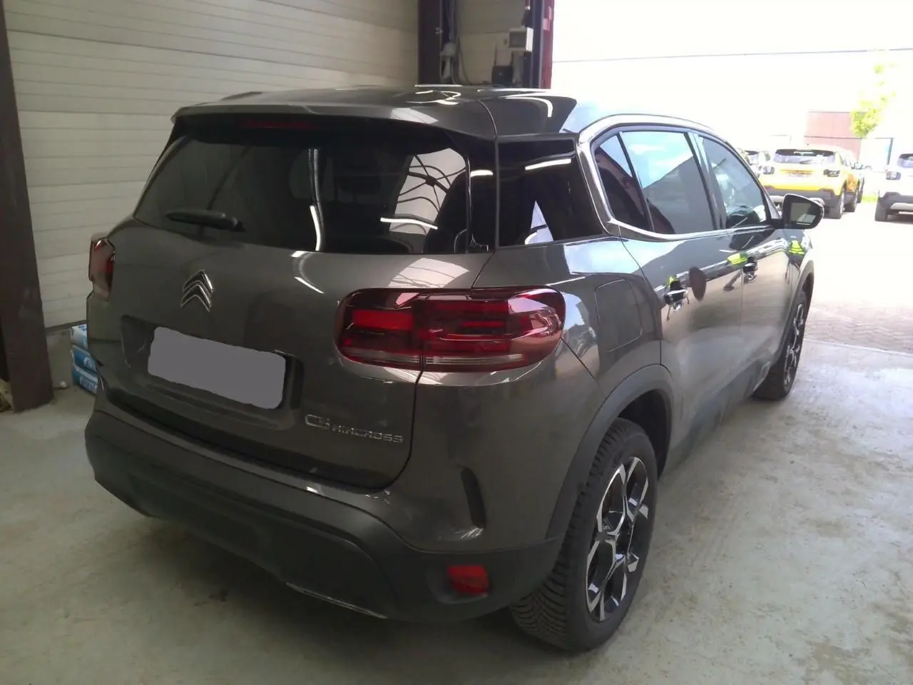 Vue 3/4 arrière droite du Citroën C5 Aircross gris platinium avec toit noir et feux arrière LED distinctifs.