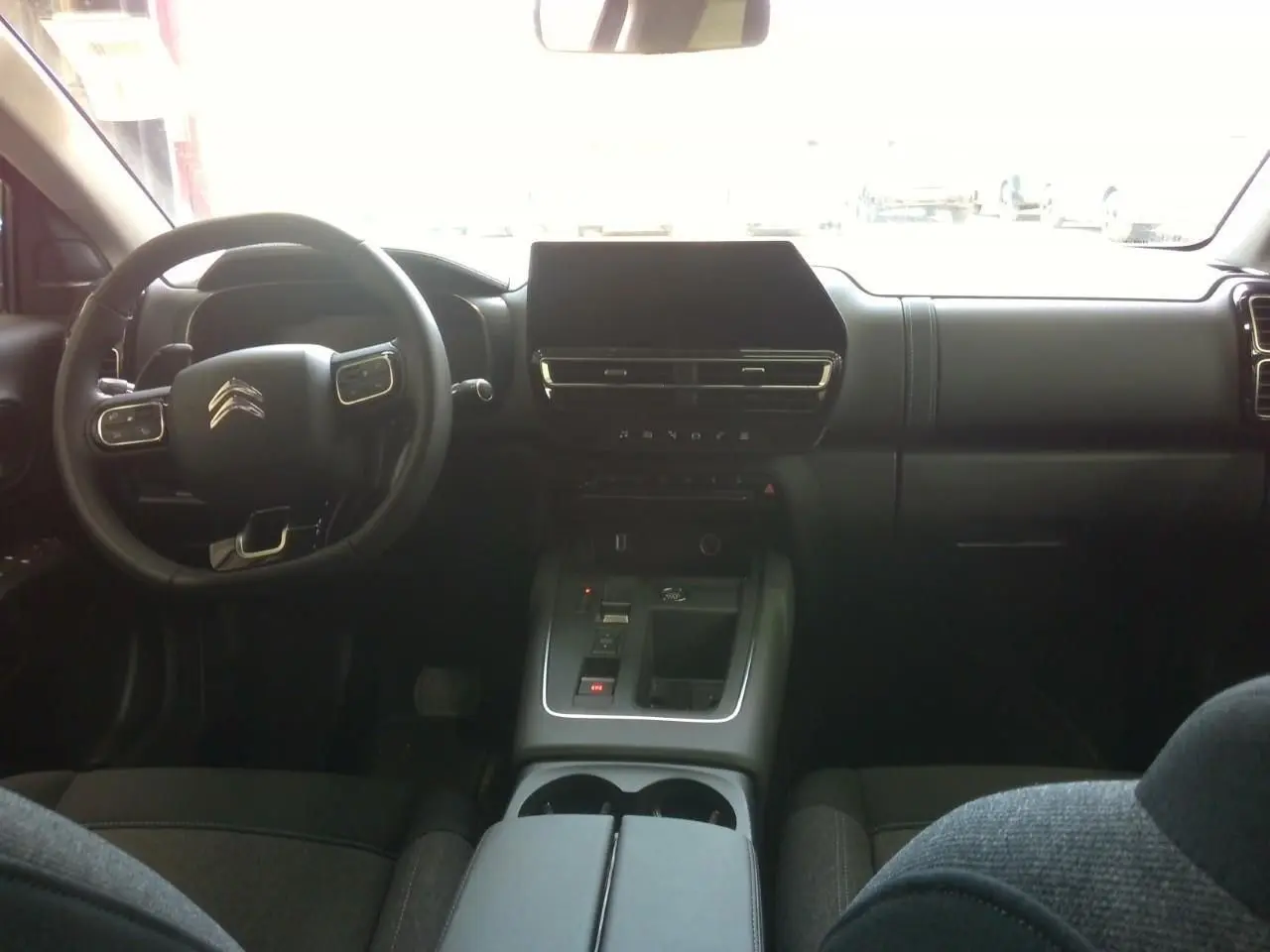 Vue intérieure avant du Citroën C5 Aircross 2025 gris platinium, avec tableau de bord moderne et écran central tactile.